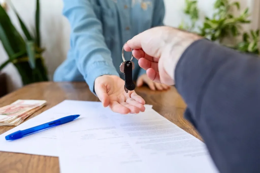 Handing over house keys during a home closing day after signing real estate documents in the United States